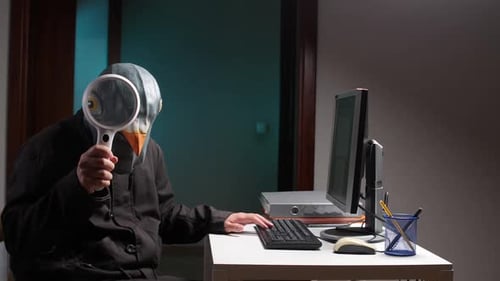 Man in Pigeon Mask Types at Computer