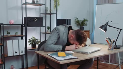 Frustrated Young Adult Working At Desk in Office