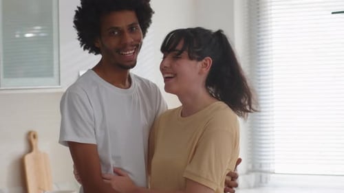 Smiling Couple Embracing in a Bright Kitchen