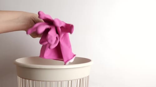 Pink Gloves Thrown in White Waste Bin