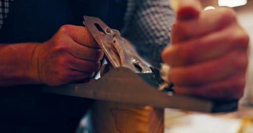 Adult Using Plane in Workshop