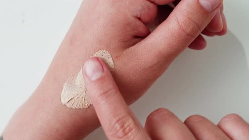 Hand Applies Cosmetic Product for Skin Test