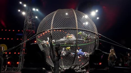 Six acteurs cascadeurs à moto dans une cage ronde lors d'un spectacle de cirque