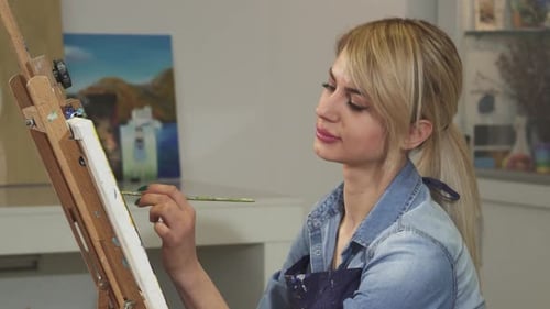 Close Up of a Beautiful Female Artist Smiling While Painting in Her Studio