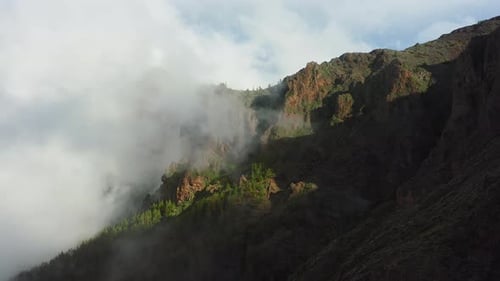 White Air Clouds Descend Down the Mountainside Into the Valley