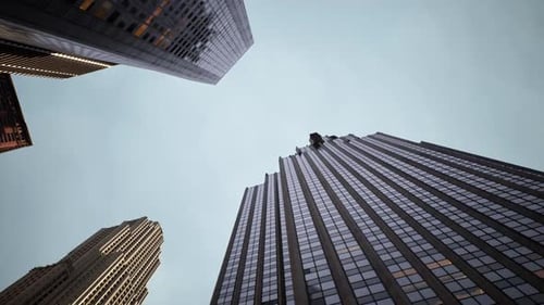 Looking Up at Tall Buildings in a Bustling Urban Area During Late Afternoon