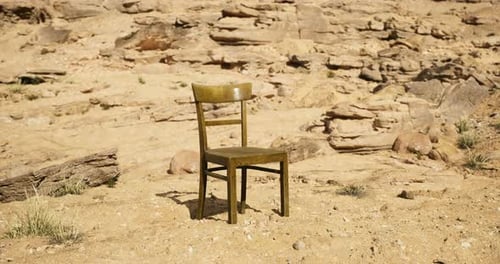 Lonely Chair Positioned in a Desolate Desert Landscape Under Bright Sunlight