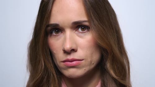 Sad brunette woman portrait with upset face expression in slow motion studio shot