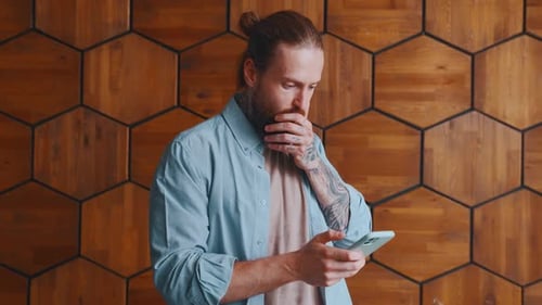 Man Reacts to News on Phone