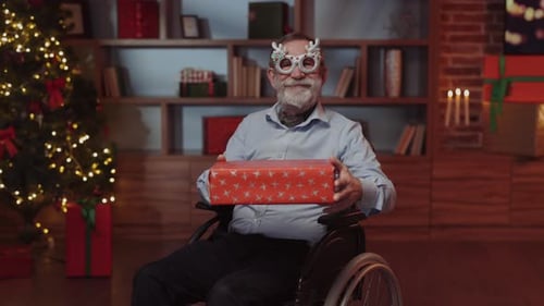 Senior Man in Wheelchair with Christmas Present