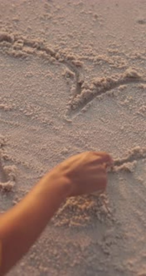 Hand-, Person- und Herzzeichnung im Strandsand, Liebeszeichen oder Romanze mit Reisen