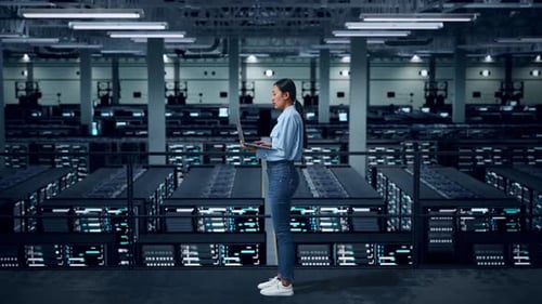 Side View Of Full Body Asian Woman Using Laptop Computer An Looking Around In Data Center