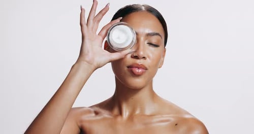 Woman, cream and smile for skincare, anti aging and hydration mask in studio on white background