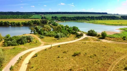 Caminos en los campos que conducen al puente sobre el estrecho río.