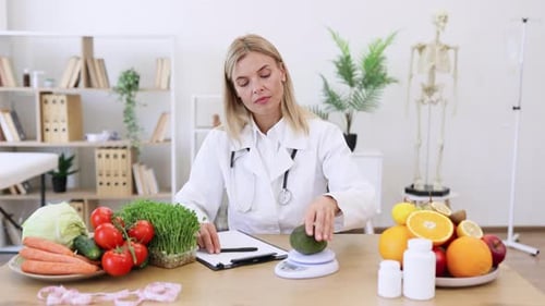 Doctor Weighing Avocado and Writing on Clipboard