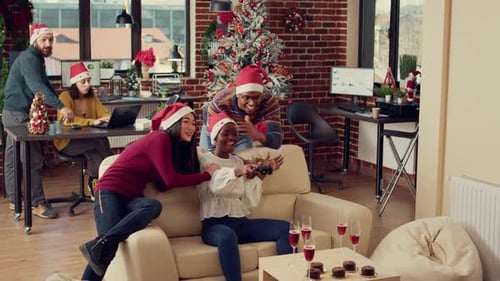 Colegas alegres jogando Vídeo na festa de Natal no escritório