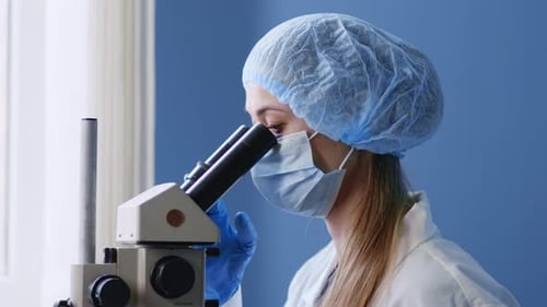 Female Medical Researcher Using Microscope in Laboratory