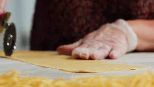Woman Using Pasta Machine to Make Fresh Pasta Dough in the Kitchen Cooking in Italian Restaurant