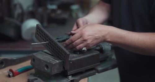 Hands Using Pliers to Cut Wire in Shop