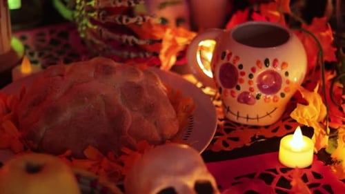 Sugar skull and pan de muerto offering on Day of the Dead altar, close up