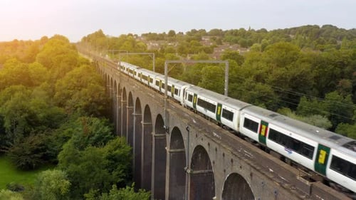Dramatic aerial drone footage of a train crossing the famous viaduct bridge.