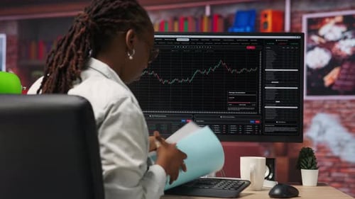 Day Trader Using PC to Sell Stocks Aiming to Capitalize on Market Trends