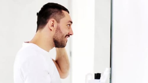 Man Combs Hair in Mirror, Morning Routine