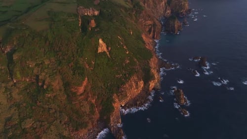 Aerial view of sunset over dramatic cliff and ocean, Portugal.