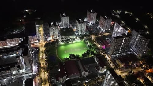 Aerial night view of George Town sports field and surrounding apartment towers