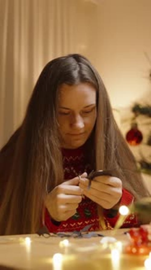 Woman Cutting Christmas Shapes at Home at Night