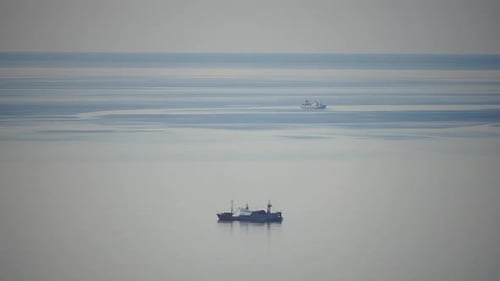 Fishing Boat Trawler Catches Fish While Sailing on Sea A Commercial Fishing Boat on the Horizon in a
