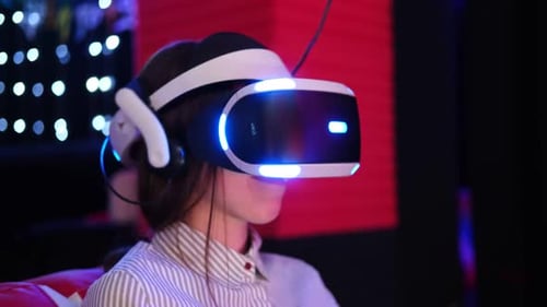 Woman using VR headset in modern dark room