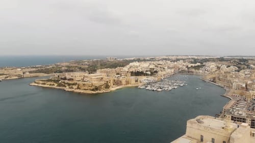 Wide panning 4k aerial drone footage of the 'Three Cities of Malta' along the coast of the Mediterra