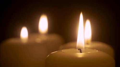 Glowing Candles Flicker in the Dark Close Up