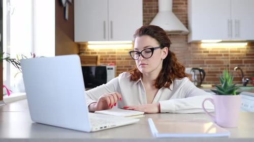Woman Works on Laptop in Bright Kitchen