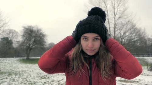 Woman in Winter Hat Adjusting her Pom-pom