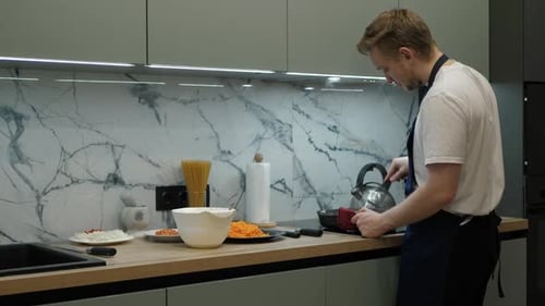 Man Cooking with Kettle in a Modern Kitchen