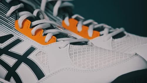 Stylish White Sneakers with Black and Orange Accents