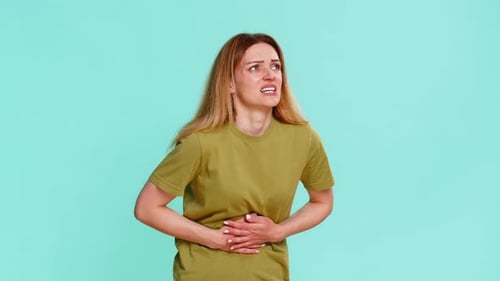 Woman Holding Stomach in Pain on Blue Background
