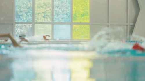 Blurred Swimmers Training in an Indoor Swimming Pool