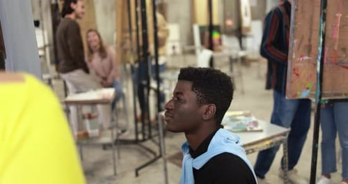 Young Multiracial Students Painting Together Inside School Art Classroom African