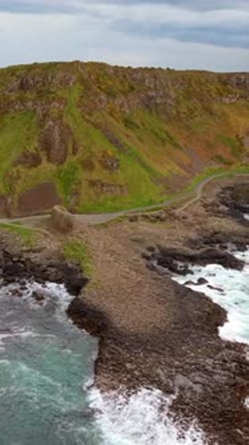 Wide, front-on social ratio aerial video of The Giant's Causeway in Bushmills, Northern Ireland