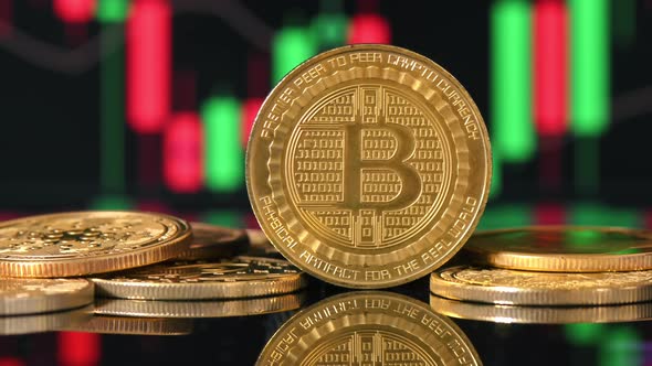 Close view of multiple physical Bitcoins with moving digital charts ...