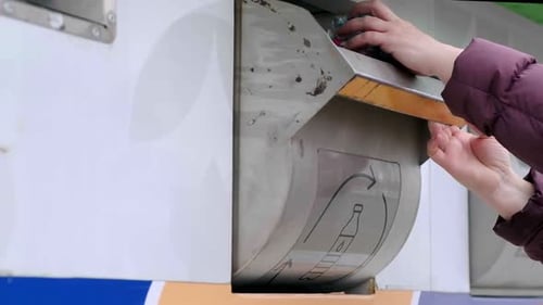 Woman Recycles Plastic Bottles in Recycling Container