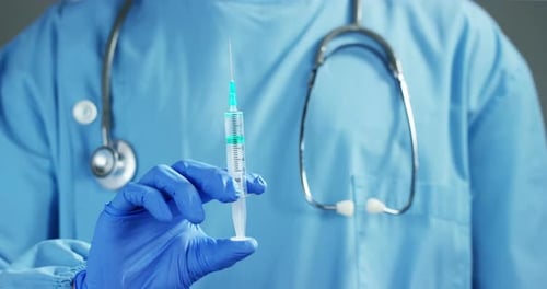 Ein Arzt oder Wissenschaftler im Labor, der eine Spritze mit flüssigen Impfstoffen für Kinder oder älter in der Hand hält