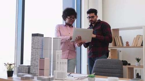 Architects Collaborating on Building Designs in Office