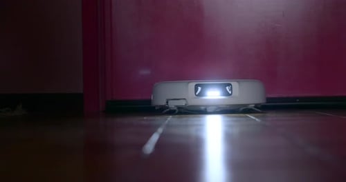 Robot Vacuum Cleaner Moving on Wood Floor