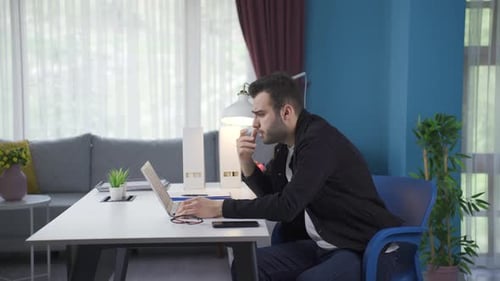 Young Adult Working on Laptop at Home Office