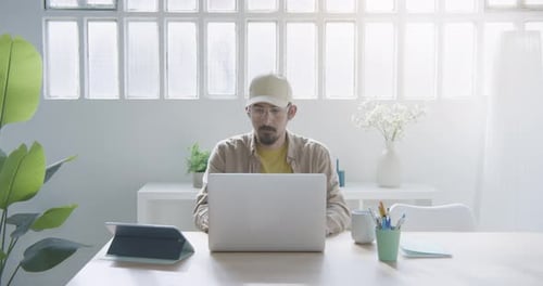 Man Working At Home On Laptop and Tablet