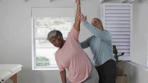 Senior Woman Assisted with Stretching Exercise